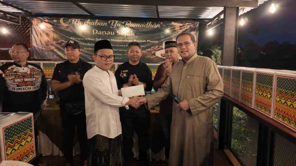 Anggota komunitas KOMBESS Sawangan memberikan santunan kepada anak yatim di acara buka bersama
